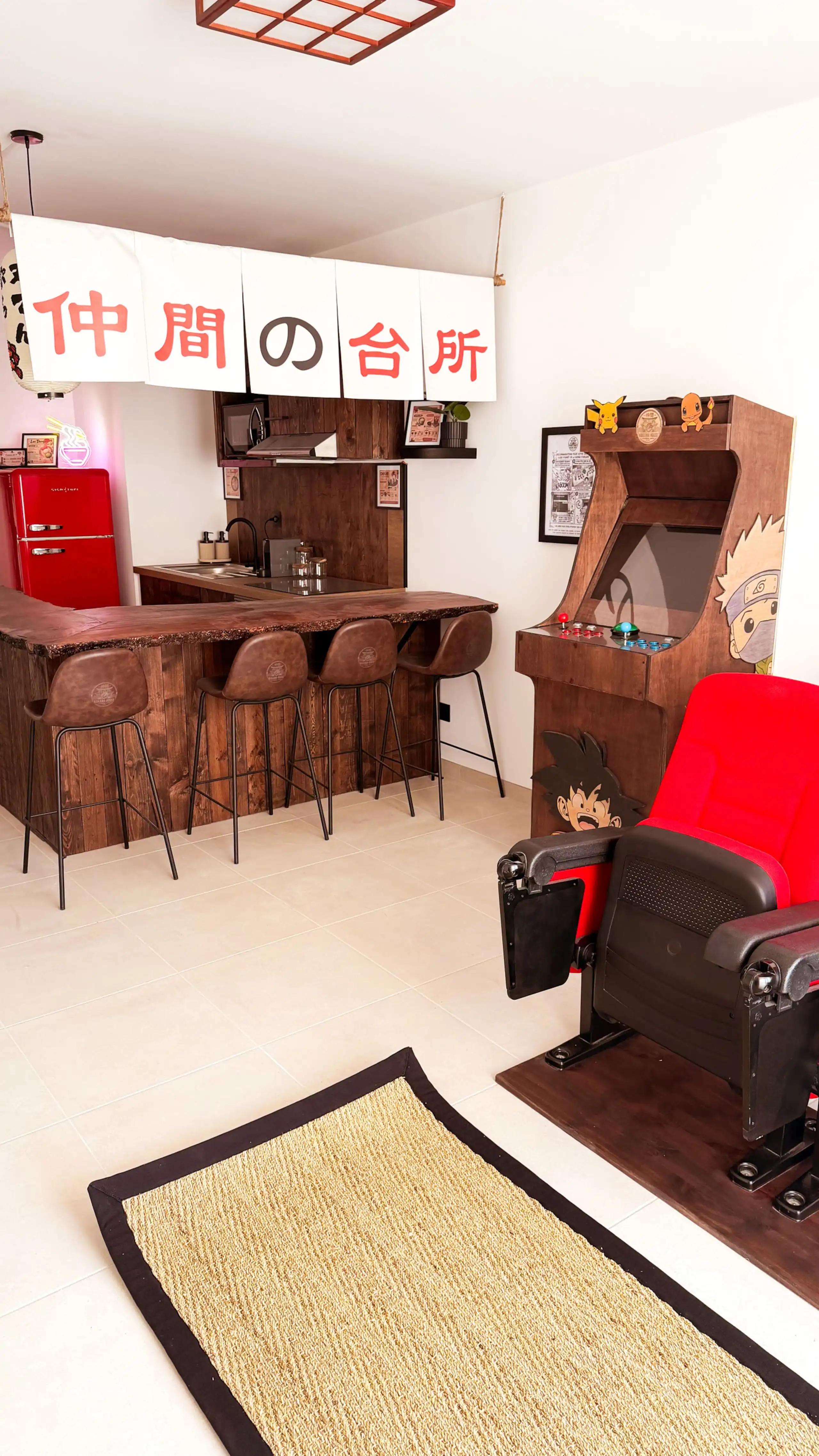 The living room at Nakama House with its genuine red cinema seats, wooden arcade cabinet and Japanese lanterns — photo 2