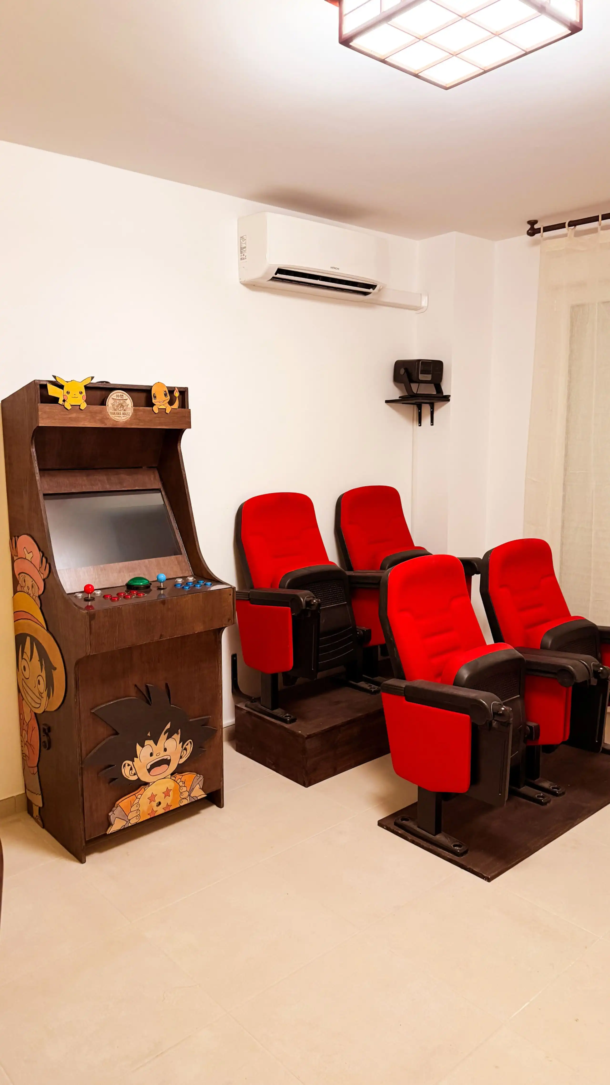 The living room at Nakama House with its genuine red cinema seats, wooden arcade cabinet and Japanese lanterns — photo 3