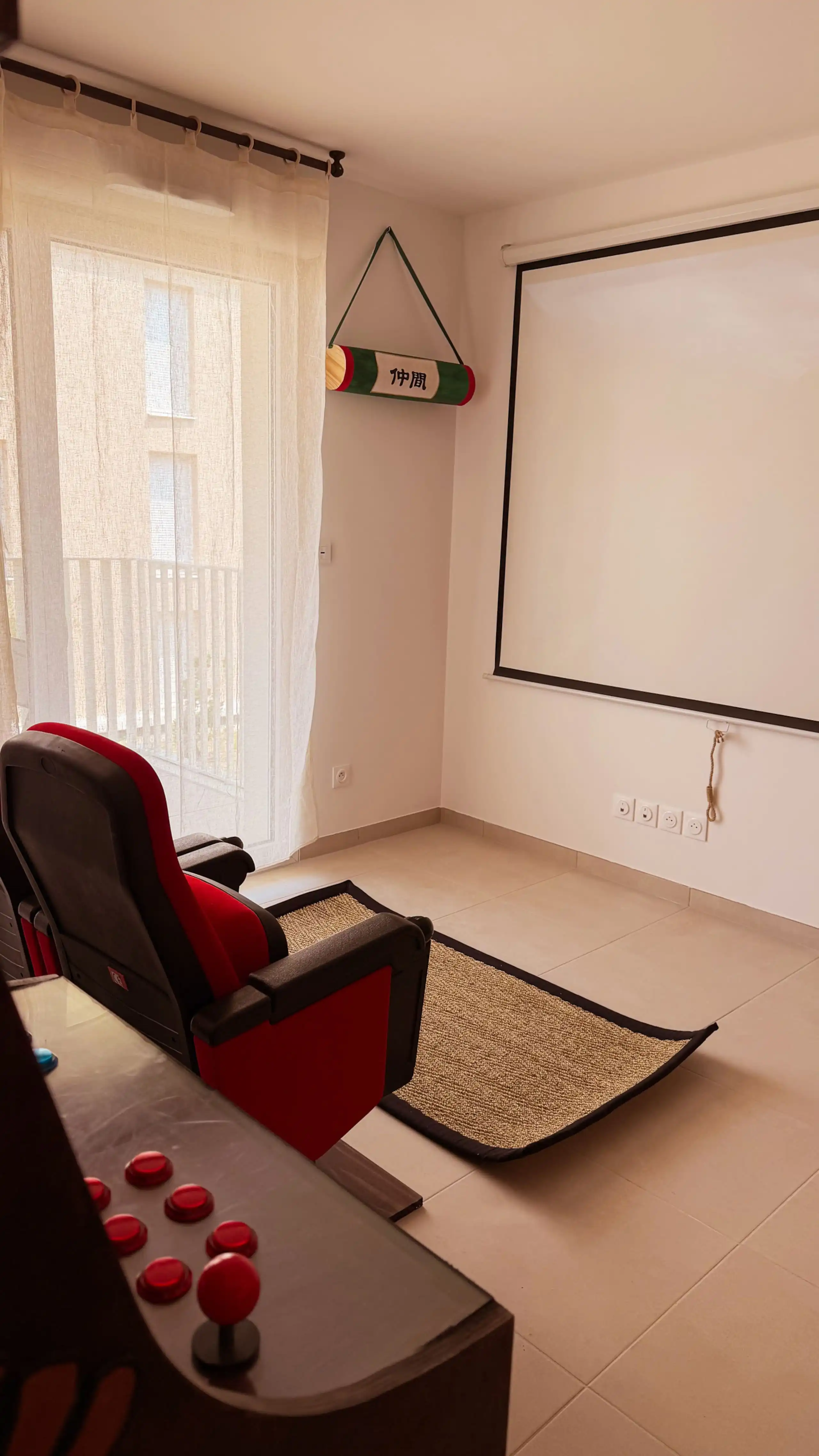 The living room at Nakama House with its genuine red cinema seats, wooden arcade cabinet and Japanese lanterns — photo 4