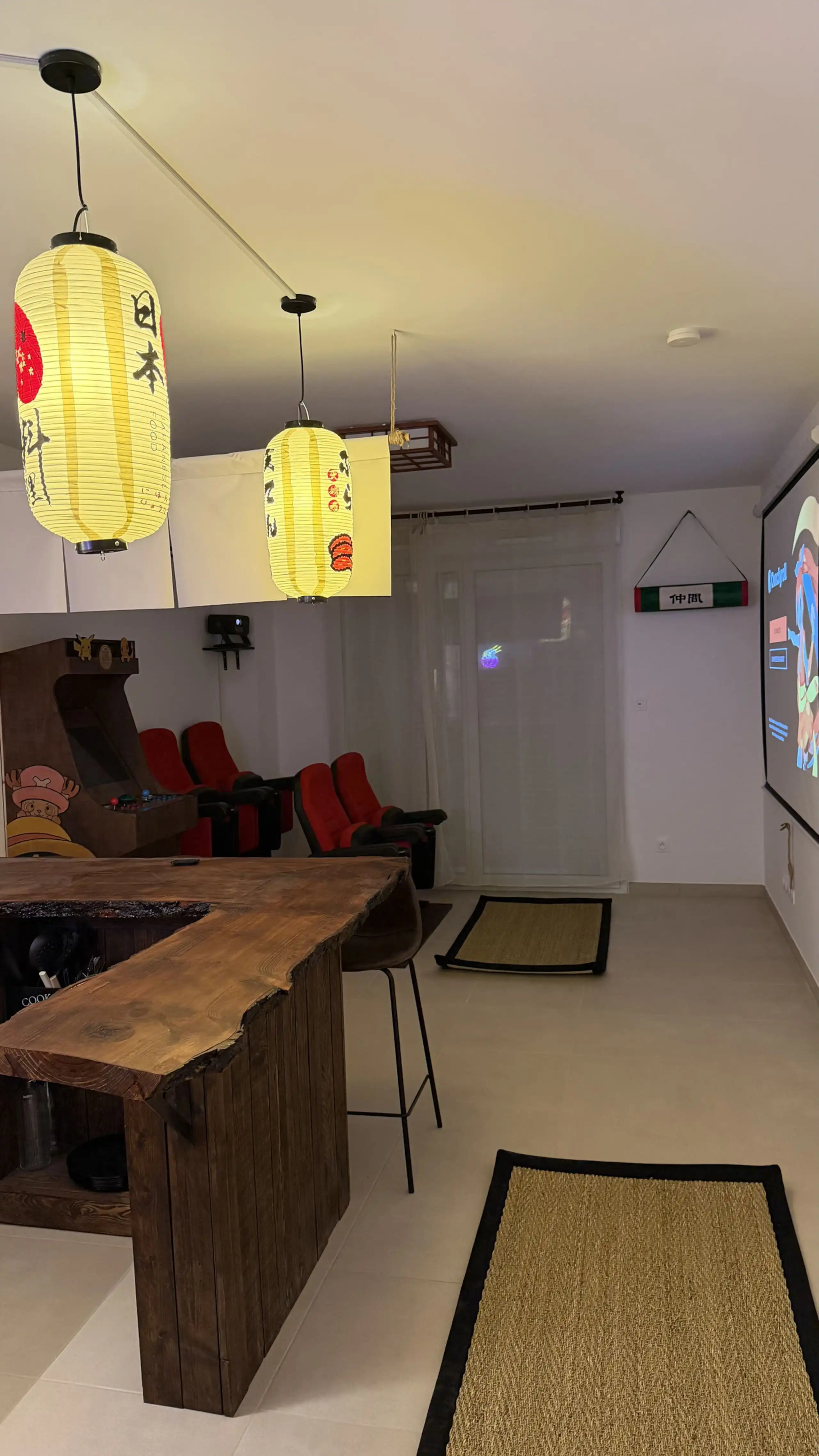 The living room at Nakama House with its genuine red cinema seats, wooden arcade cabinet and Japanese lanterns — photo 5
