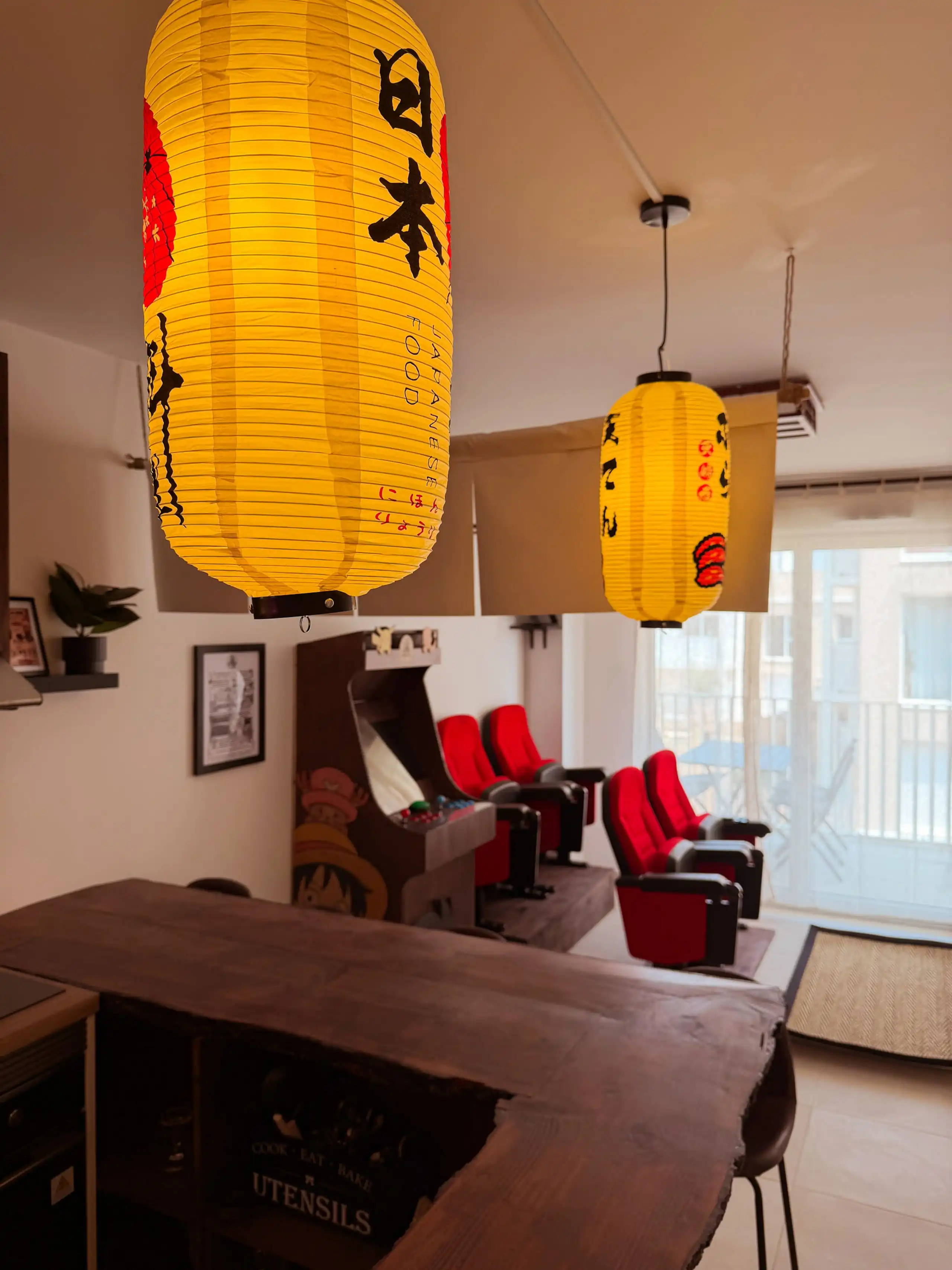 The living room at Nakama House with its genuine red cinema seats, wooden arcade cabinet and Japanese lanterns — photo 6