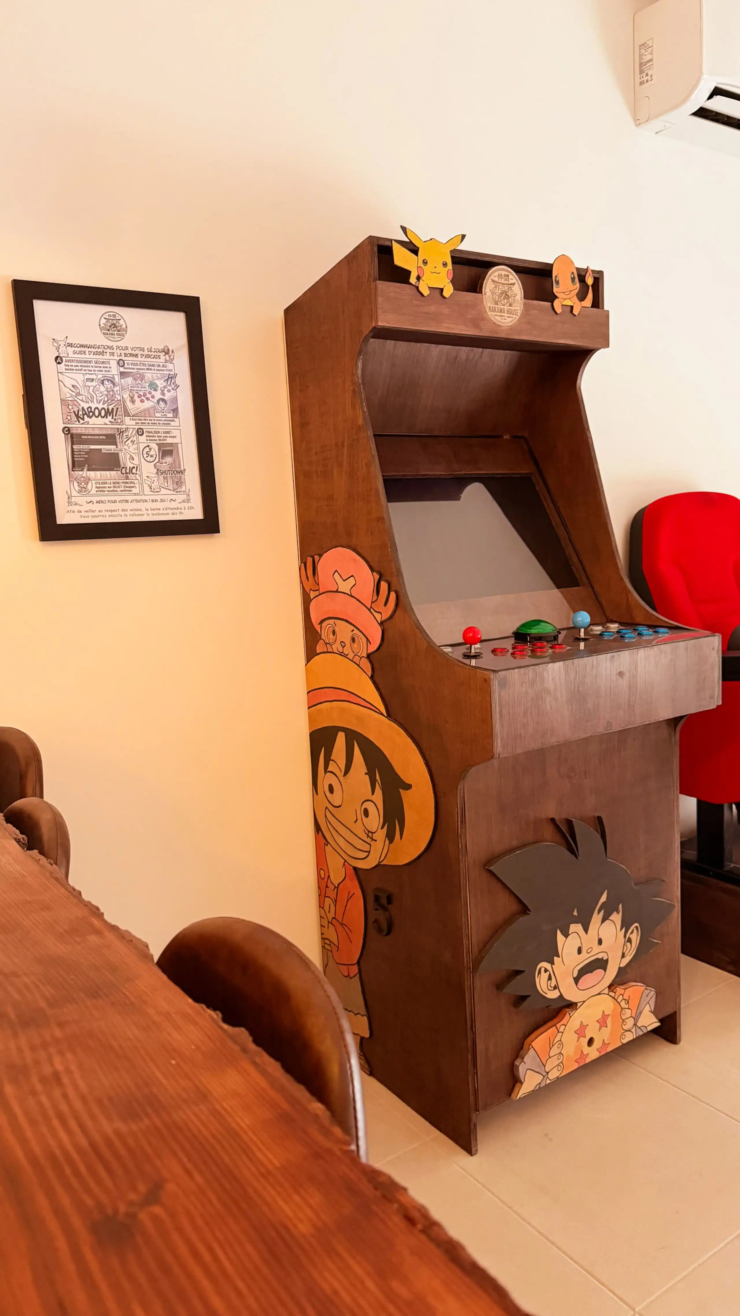 The living room at Nakama House with its genuine red cinema seats, wooden arcade cabinet and Japanese lanterns — photo 7