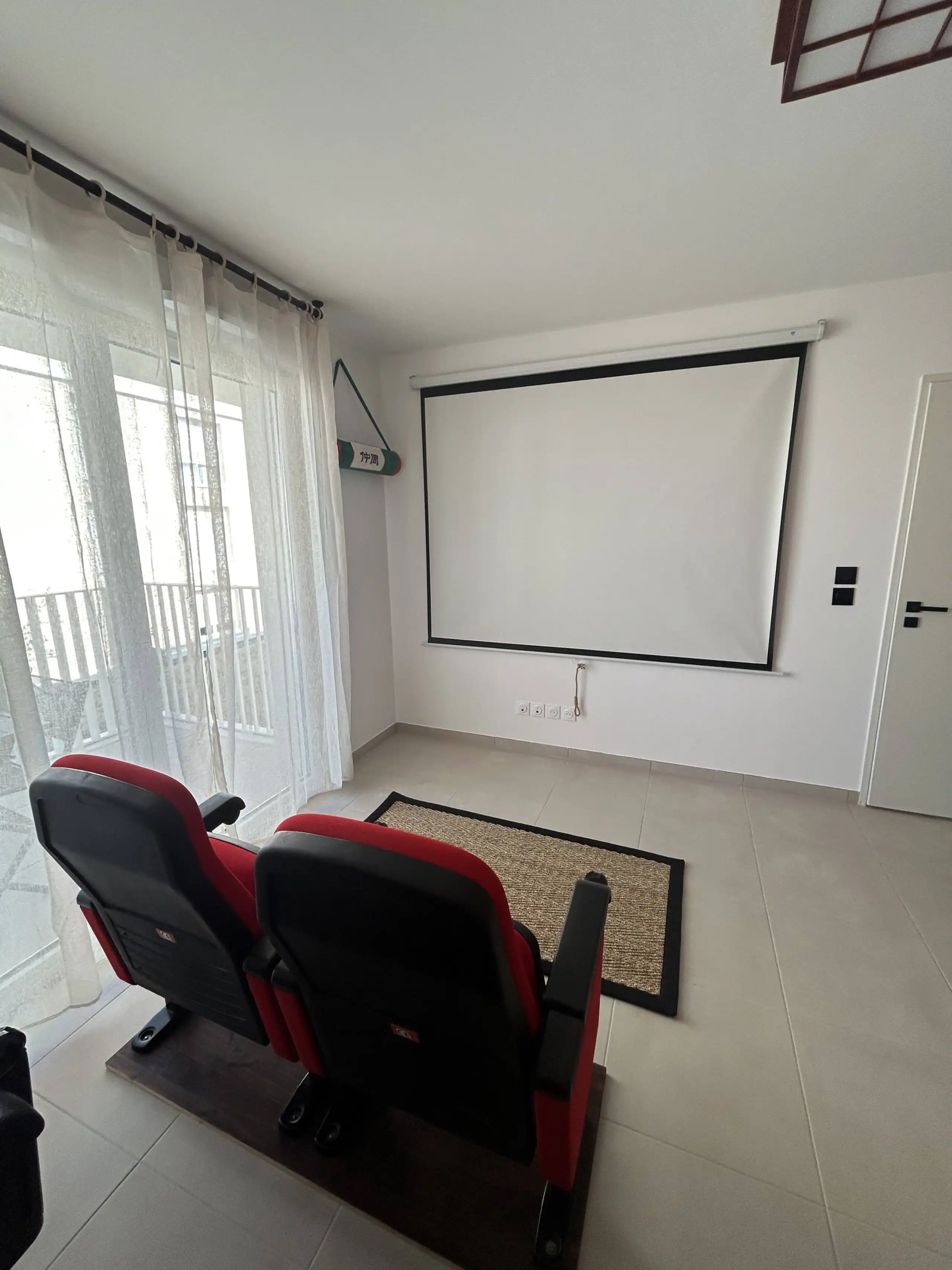 The living room at Nakama House with its genuine red cinema seats, wooden arcade cabinet and Japanese lanterns — photo 9